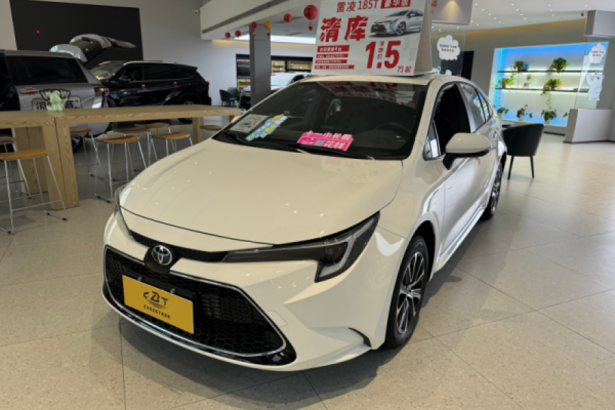 A white Toyota Levin sedan is displayed in a modern dealership, with a promotional sign advertising a clearance sale.