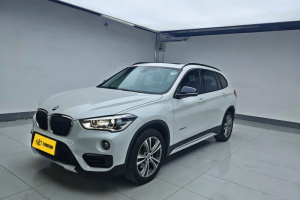 White BMW X1 M Sport SUV in indoor showroom, side-front view with alloy wheels, roof rails and yellow license plate.
