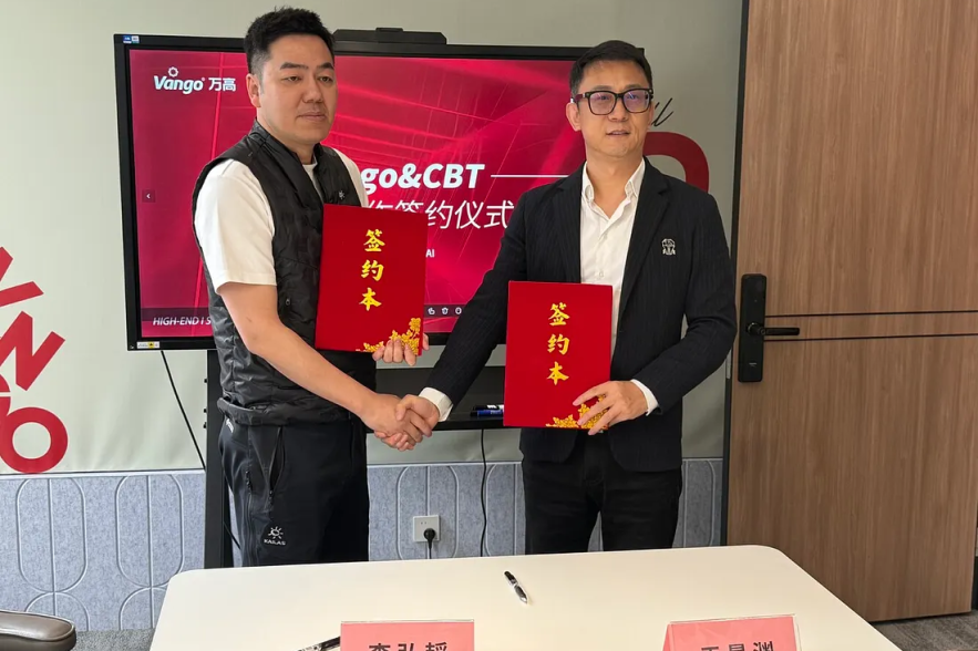 Two men signing documents at the Vango & CBT cooperation ceremony.