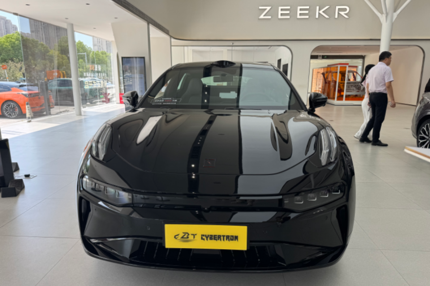 A glossy black Zeekr electric vehicle is prominently displayed in a modern car showroom.