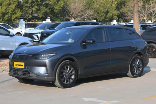 Matte dark gray EV wagon with sleek LED headlights and multi-spoke alloy wheels