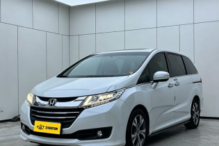 White Honda Odyssey family MPV three-quarter front view shot inside clean minimalist indoor car photography studio