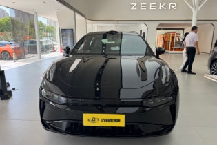 A glossy black Zeekr electric vehicle is prominently displayed in a modern car showroom.