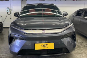 Close-up front fascia of grey BYD EV with seamless LED light strip and yellow display plate indoors