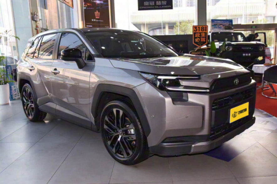 A silver Toyota SUV with a modern, rugged design is displayed in a car showroom.