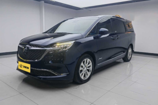 Black Buick MPV in a showroom, three-quarter view.